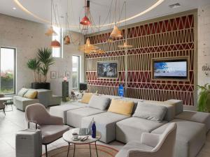 a living room with a white couch and chairs at Novotel Arica in Arica