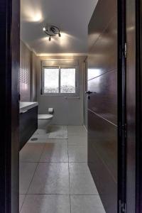 プラヤ・パライソにあるDBL Paradiseのバスルーム(トイレ、洗面台付)、窓が備わります。