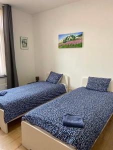 two beds in a room with blue and white at Hébergement Citabelle in Dinant