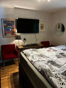 a bedroom with a bed and a flat screen tv at Comfortable stay near Gothenburg with private sauna and coast nearby in Billdal