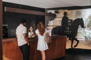 a man and a woman standing at a bar at Hotel Les Haras By Stay Collection in Strasbourg