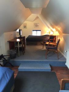 um quarto com uma cama, uma secretária e uma mesa em Reersø Kro em Reersø