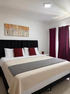 a bedroom with a large bed with red pillows at Vista al Caribe in La Francia +22 photos