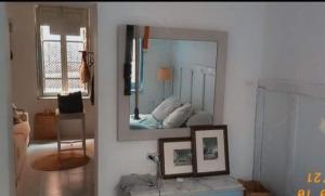 a mirror on a wall in a room with a bed at Casa granada in Atarfe
