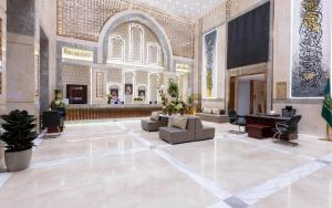 a large lobby with a couch and a piano at Grand Millennium Al Haram Hotel in Medina +29 photos