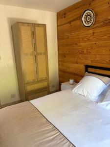 a bedroom with a large white bed with a wooden headboard at Charmant chalet en montagne in Petreto-Bicchisano