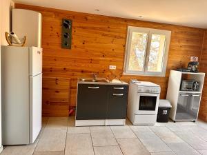 a kitchen with white appliances and wooden walls at Charmant chalet en montagne in Petreto-Bicchisano +8 photos