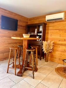 a room with a wooden wall with a table and stools at Charmant chalet en montagne in Petreto-Bicchisano
