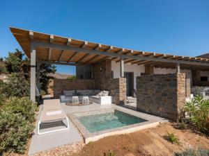 a backyard with a swimming pool and a pergola at Villa Ena - Beach getaway in Logaras