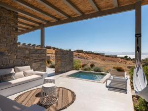 a patio with a couch and chairs and a swimming pool at Villa Ena - Beach getaway in Logaras