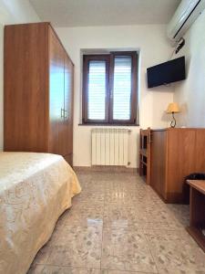 a bedroom with a bed and a flat screen tv at Hotel Edelweiss in Laino Borgo