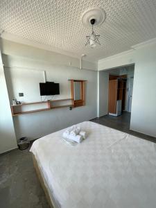 Ein Schlafzimmer mit einem großen Bett und einem Fernseher an der Decke. in der Unterkunft Hisar Beach Hotel in Yaylacık + 8 Fotos
