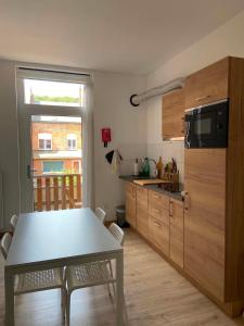 a kitchen with a white table and a table and chairs at Hébergement Citabelle in Dinant