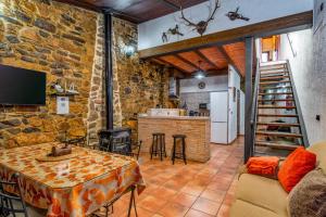 a living room with a table and a kitchen at Casa rural rio yeguas in Azuel