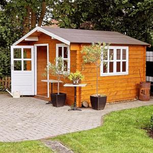 a small wooden shed with a table in a yard at Schlosspartie stilvolle Ferienwohnung an der Nordsee in Sande