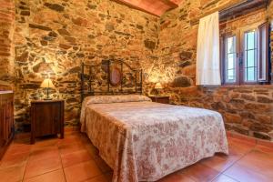 a bedroom with a bed and a stone wall at Casa rural rio yeguas in Azuel +43 photos
