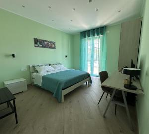 a bedroom with a bed and a desk and a window at B&B Gino&Giulia in Aprilia
