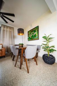 a living room with a table and chairs and a plant at 6BR Beachfront Compound w-Generator & Games in Camuy