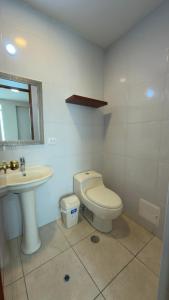a bathroom with a toilet and a sink at Hotel Residencial Paris in Arequipa