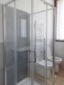 a bathroom with a glass shower with a toilet at Oasi Bernareggio Smart Work & Relax in Bernareggio +4 photos