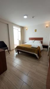 a bedroom with a large bed and a wooden floor at Hotel Residencial Paris in Arequipa