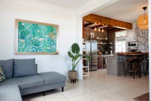 a living room with a couch and a kitchen at 6BR Beachfront Compound w-Generator & Games in Camuy