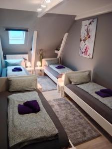 a room with three beds and purple pillows at FördeFlats in Flensburg