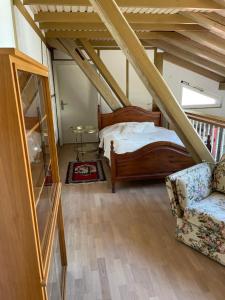 a bedroom with a bed and a chair in a attic at Landidyll Engelhofen in Obersontheim