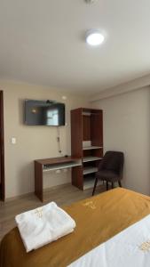a bedroom with a bed and a desk and a chair at Hotel Residencial Paris in Arequipa