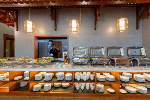 a buffet line with plates and dishes on display at Yes Hotel Đà Nẵng in Danang