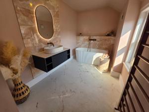 a bathroom with two sinks and a tub and a mirror at Fox House Llandudno in Llandudno +12 photos