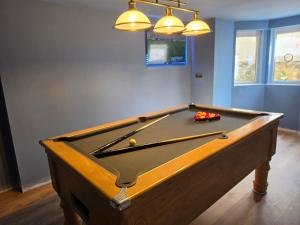 a pool table in a room with two lights at Fox House Llandudno in Llandudno