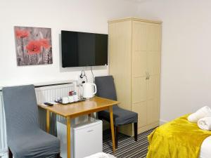 a room with a desk and two chairs and a bed at Edinburgh full bliss in Edinburgh