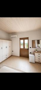 a large room with white cabinets and a wooden ceiling at Versailles Rooms in Dukati i Ri