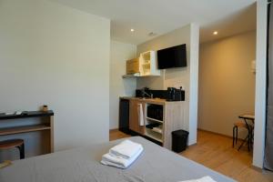 a room with a bed and a tv on a wall at Studio S Les Suites Du Roubion in Montélimar