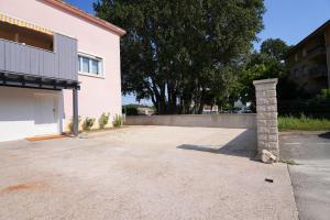 a driveway with a brick pillar next to a building at Studio S Les Suites Du Roubion in Montélimar