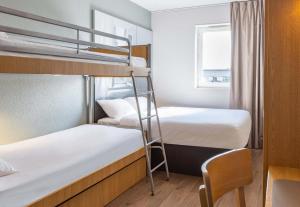 a small room with two bunk beds and a window at B&B HOTEL Rennes Est Cesson Sévigné 3 étoiles in Cesson-Sévigné