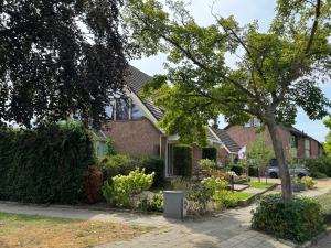 a house with a tree in front of it at De kleine Bongerd -The little Orchard in Hengelo +21 photos