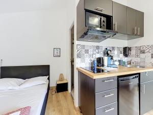 a small kitchen with a bed in a room at Le Montgy - Studio tout confort à Royat National N1 in Royat