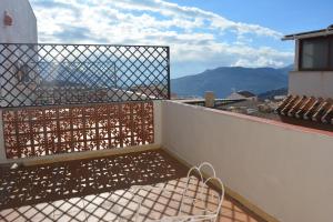 a balcony with a bench on top of a building at Hostal Manolete in Lanjarón