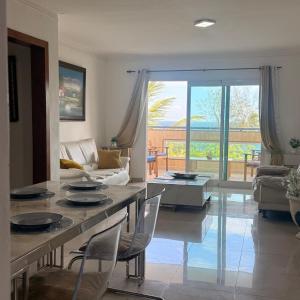 a living room with a table and chairs and a couch at Vista al Caribe in La Francia