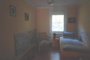 a bedroom with a bed and a chair and a window at Arbshagen in Groß Kordshagen