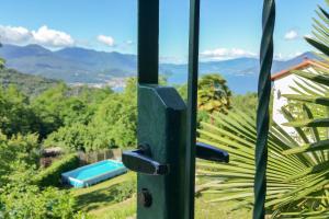 a door with a view of a pool and mountains at Residenza sul Lago Maggiore in Luino