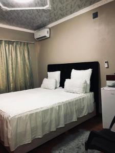 a bedroom with a bed with white sheets and pillows at No 12 in Rustenburg +36 photos