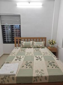 a bedroom with a bed with a blanket and a window at Uthram Avenue in Tāmarakulam