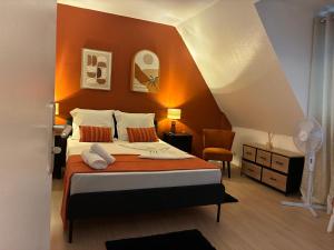 a bedroom with a bed with an orange wall at Studio Centre Strasbourg in Strasbourg