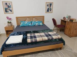 a bedroom with a bed and a desk and a chair at Uthram Avenue in Tāmarakulam