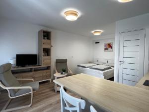 a living room with a table and a bed at Best Apartman Lelle 2 in Balatonlelle