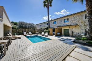 a backyard with a swimming pool and a house at Le Mas Des Brunes in Saint-Laurent-dʼAigouze