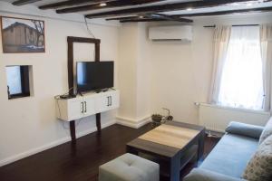 a living room with a tv and a couch and a table at Бекяровата къща in Spasovtsi +5 photos